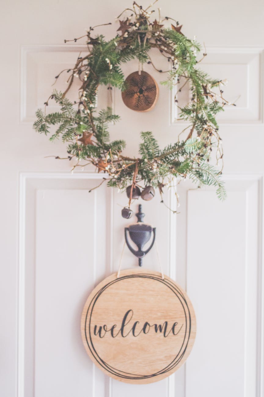 photo of a white door with a hanging wreath and welcome decor